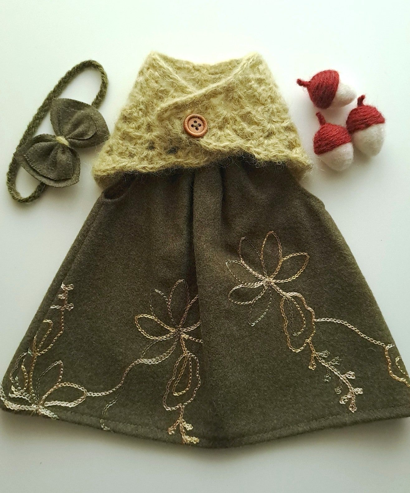 Green woollen dress with delicate gold chain embroidery detail, alpaca crochet shawl and little grren bow.