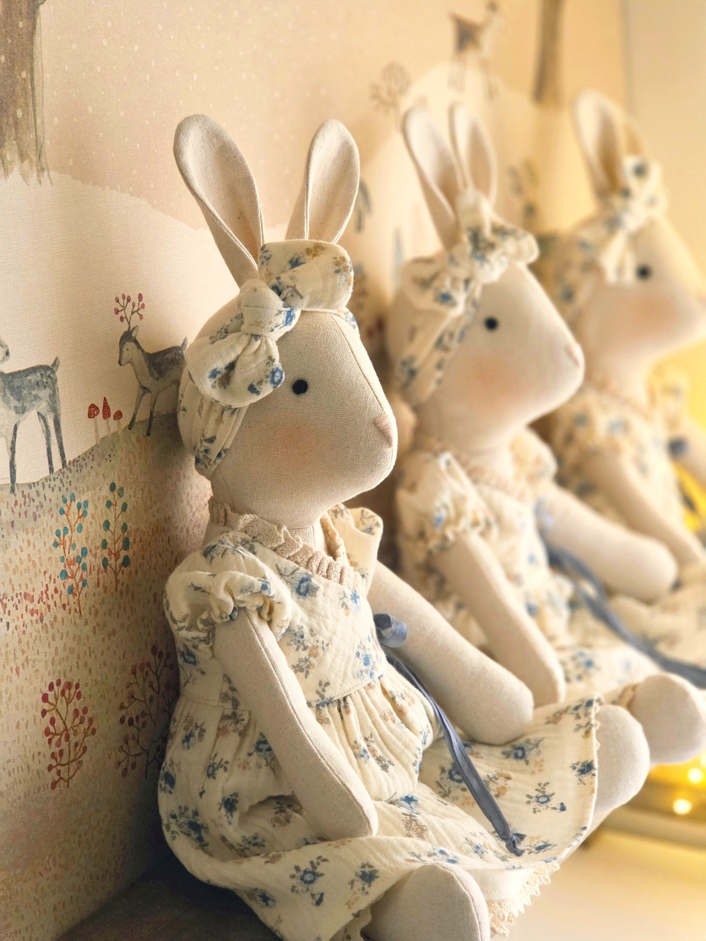 Veronica Bunny collection in soft floral dresses, handmade heirloom bunnies in a warm, storybook setting
