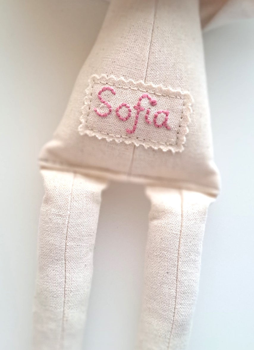 Personalised handmade linen bunny with hand-embroidered name label in pink thread on the back.
