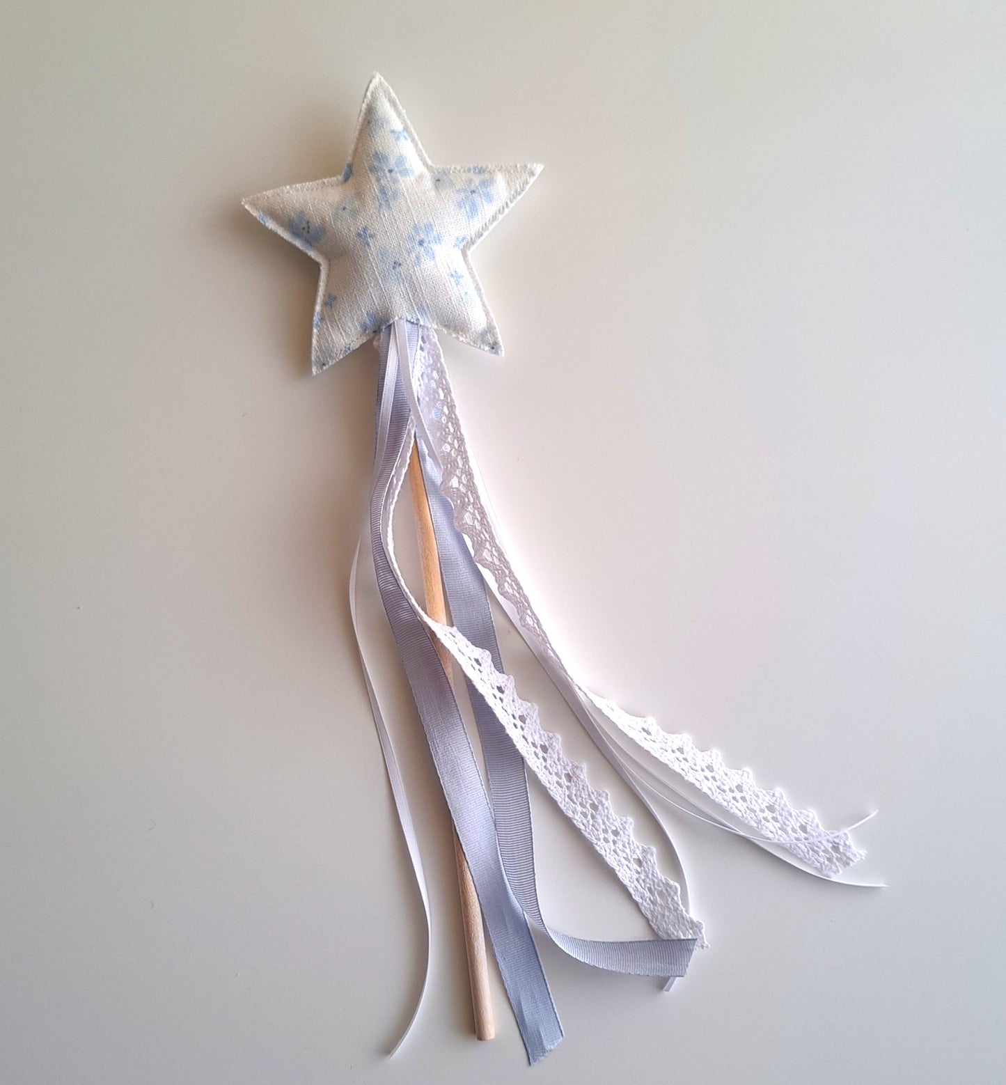 Handmade blue star party wand with soft floral fabric, wooden handle, white lace and blue ribbon streamers.