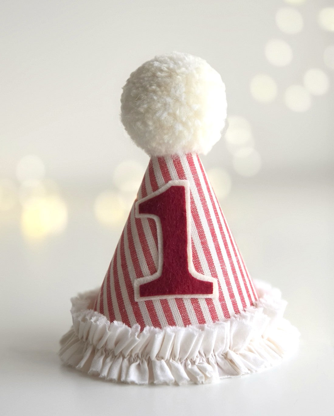 Red and white circus style first birthday hat with number 1 and soft fabric ruffle trim