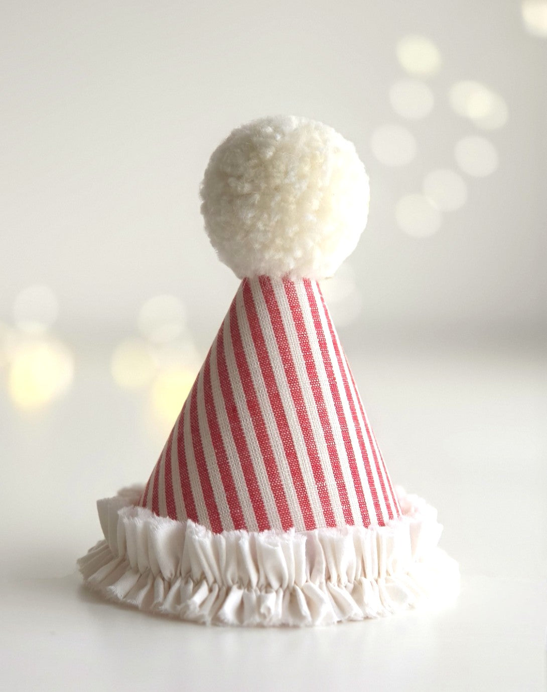 Red and white striped handmade circus party hat with soft ruffle trim and pom pom top