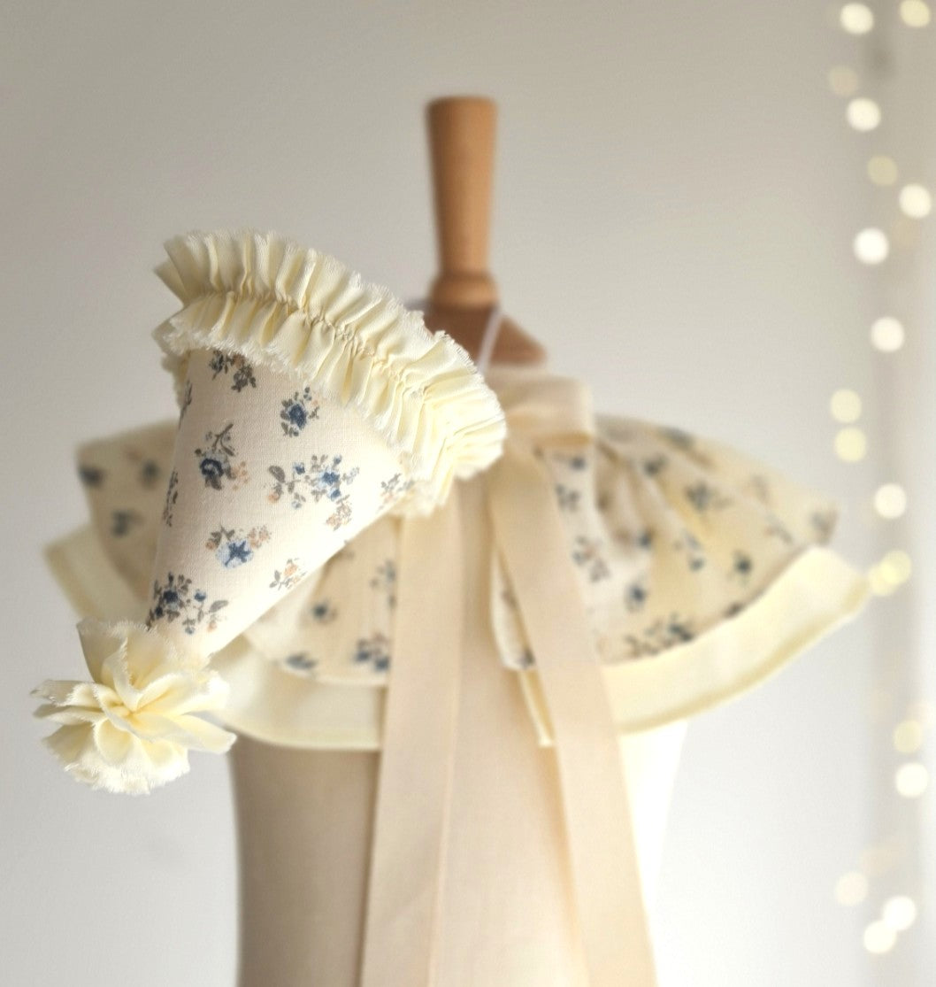 Vintage-inspired Mabel floral birthday set with pale lemon party hat and matching cape in delicate blue floral cotton.