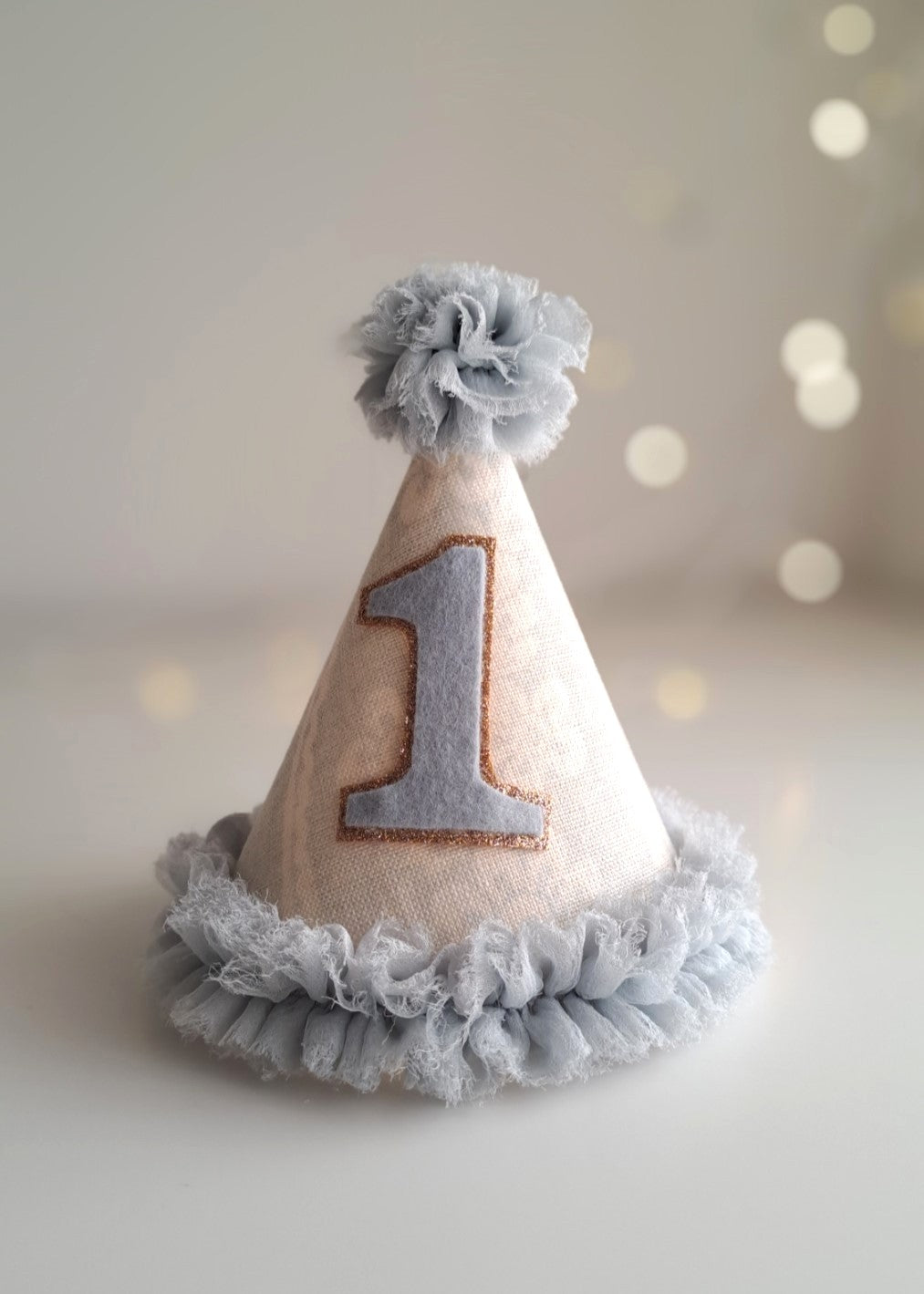 Pale blue number 1 birthday party hat with linen cone, soft blue ruffle trim and felt number, handmade by Verity Isabelle.