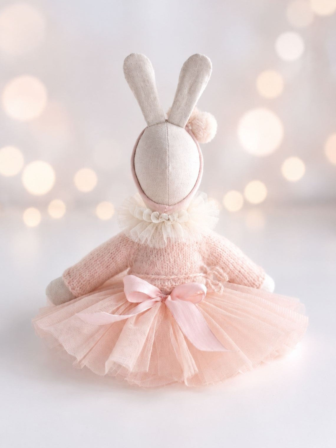 Back view of handmade Verity Ballerina Bunny wearing a pink knitted cardigan and tulle tutu with satin bow.