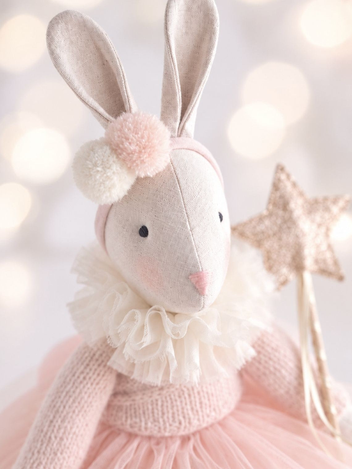 Close-up of Verity Ballerina Bunny with pom-pom headband, chiffon ruffle collar and pink knitted cardigan.