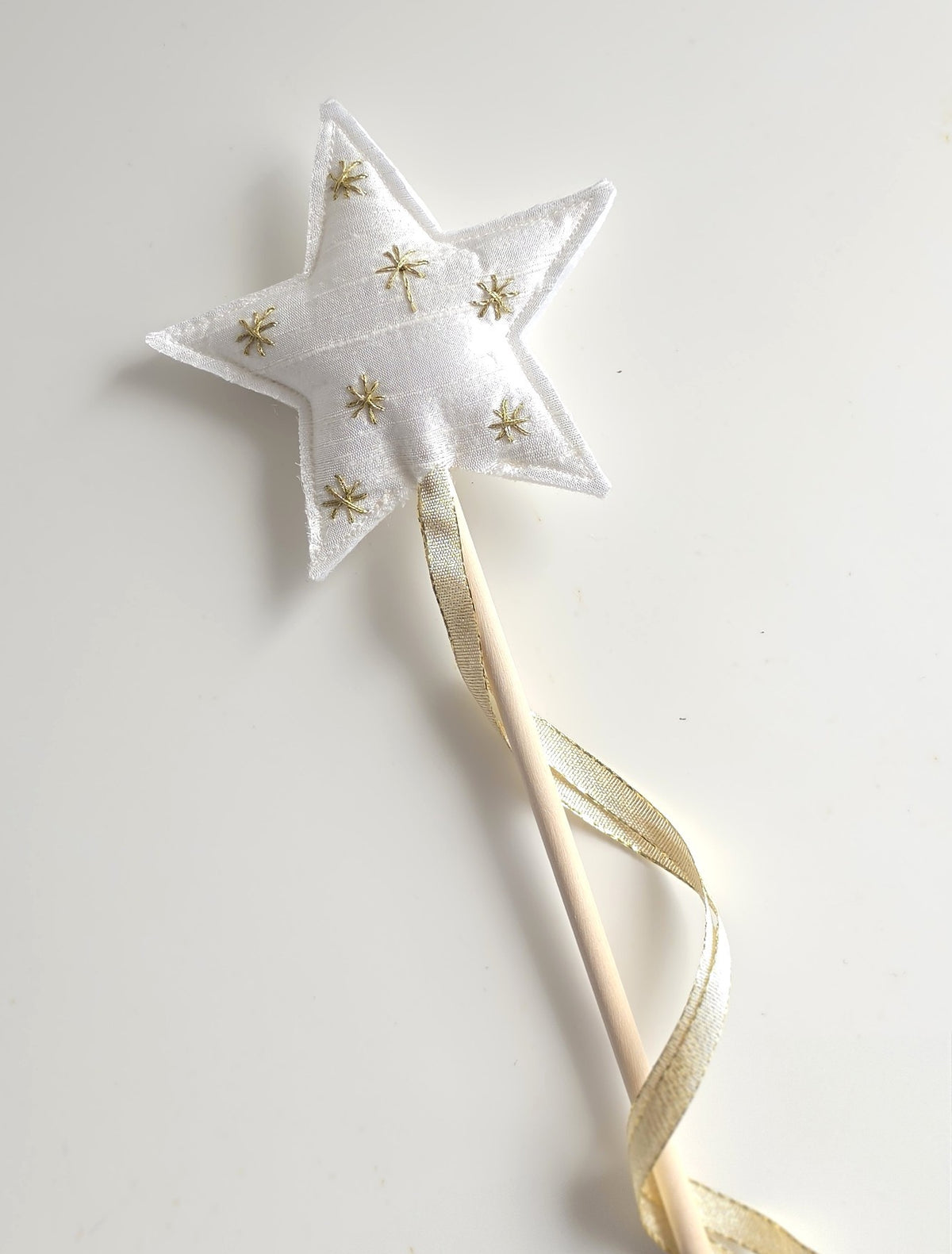 White silk Christmas star wand with hand-embroidered gold stars, wooden handle and flowing gold ribbon.