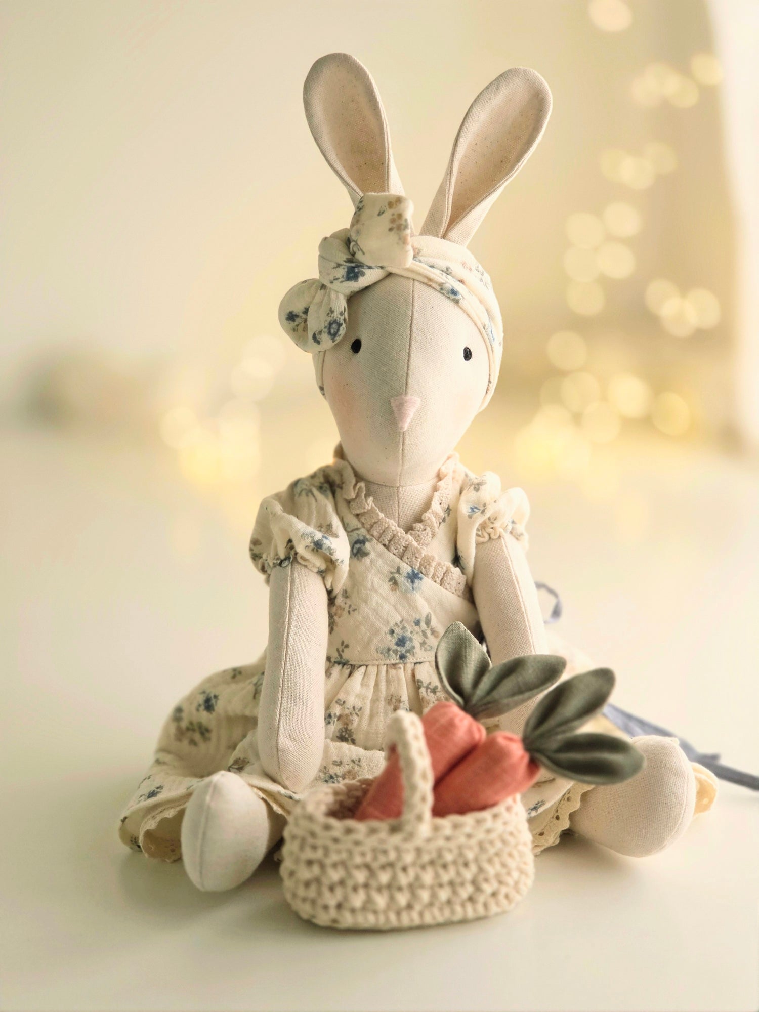 Veronica Bunny seated with crocheted basket of linen carrots, soft springtime handmade toy scene
